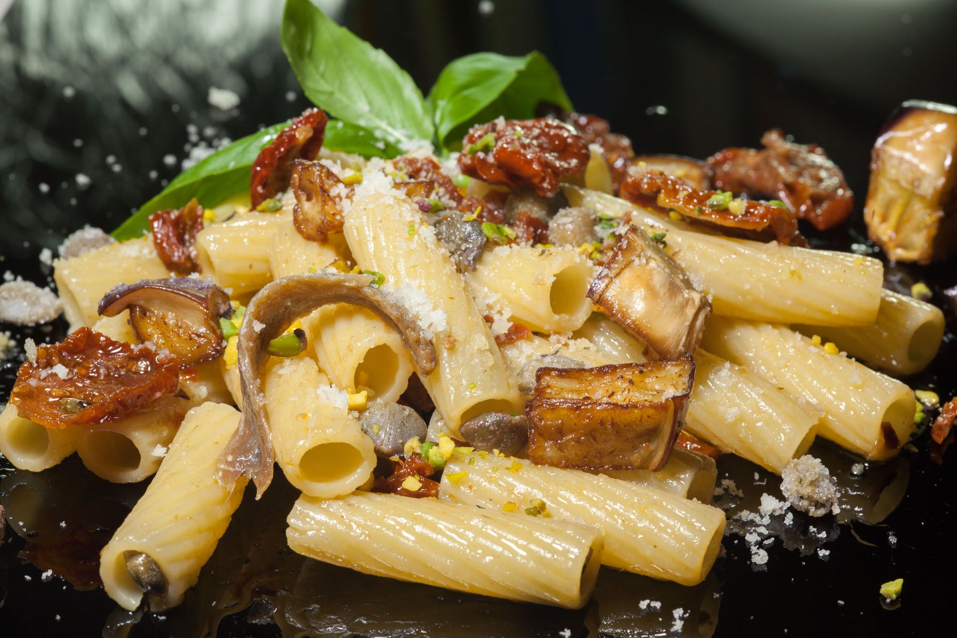 Penne con melanzane, capperi, basilico, pomodori secchi ed acciughe