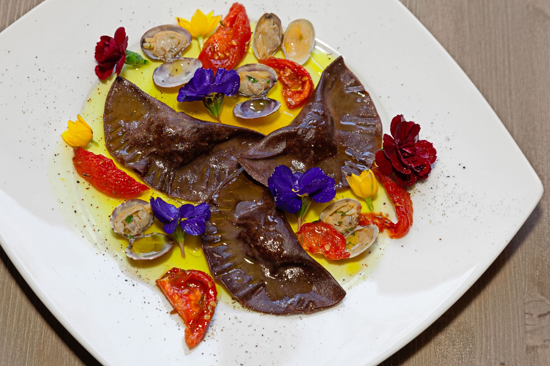 Tortelli al cacao con vongole e pomodori confit