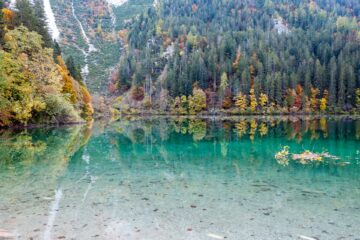 Vista autunnale del Lago di Tovel con riflessi d'acqua e alberi colorati, Val di Non, Trentino
