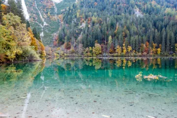 Vista autunnale del Lago di Tovel con riflessi d'acqua e alberi colorati, Val di Non, Trentino