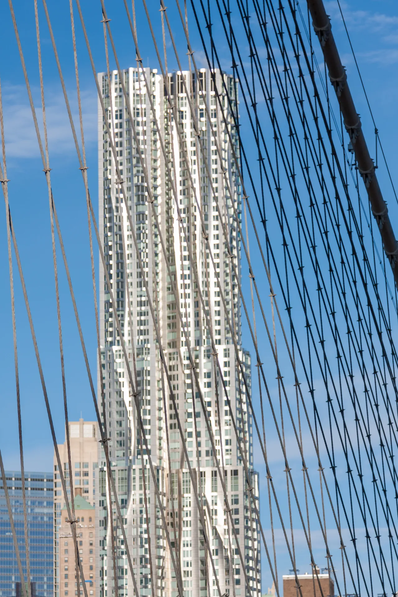 Grattacielo moderno di New York visto attraverso i cavi sospesi del Ponte di Brooklyn.