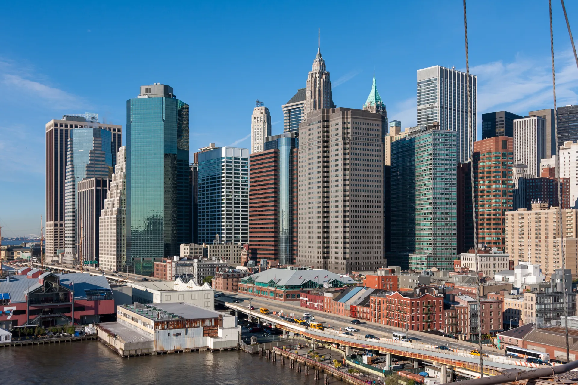 Skyline di New York visto dal Ponte di Brooklyn, con edifici iconici all'orizzonte.