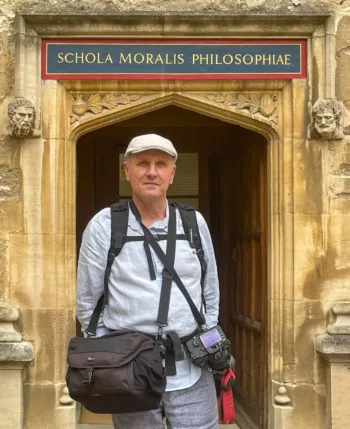Nicola Muraro di fronte alla Schola Moralis Philosophiae a Oxford, con attrezzatura fotografica, all'interno della Bodleian Old Library. Immagine storica e culturale nel contesto dell'Università di Oxford.