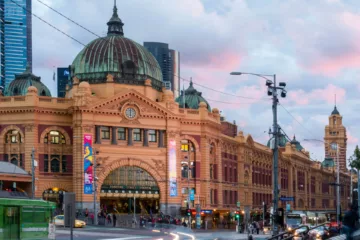 Flinders Street Station a Melbourne, con l'ingresso principale affollato e l'orologio storico visibile sopra le porte.
