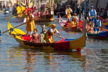 Imbarcazione gialla con vogatori in costumi storici durante la Regata Storica di Venezia