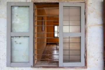 Vista di una cella del Tuol Sleng attraverso una finestra con sbarre, Phnom Penh.
