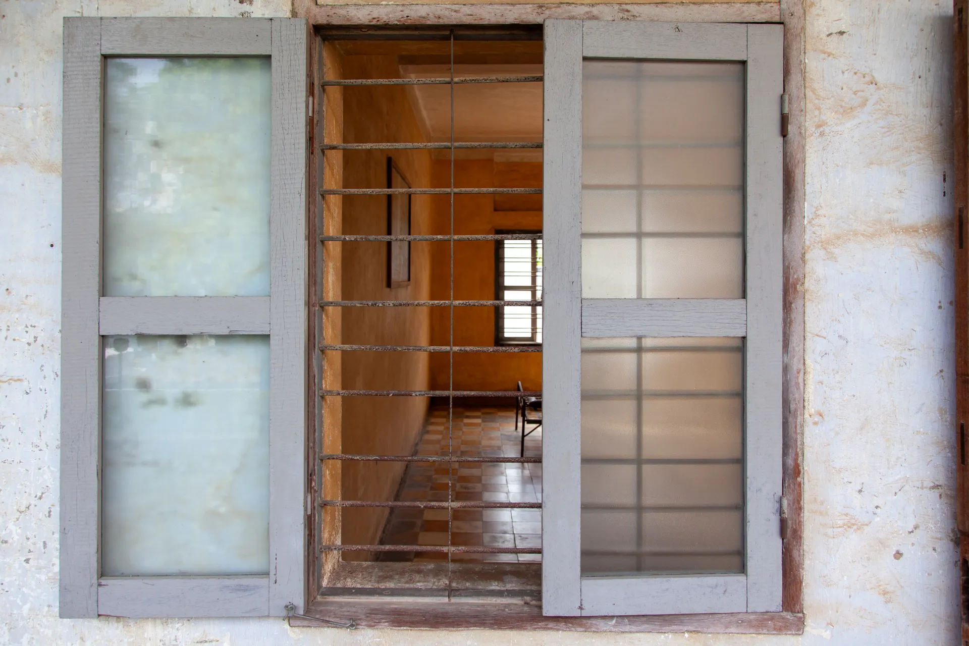 Vista di una cella del Tuol Sleng attraverso una finestra con sbarre, Phnom Penh.