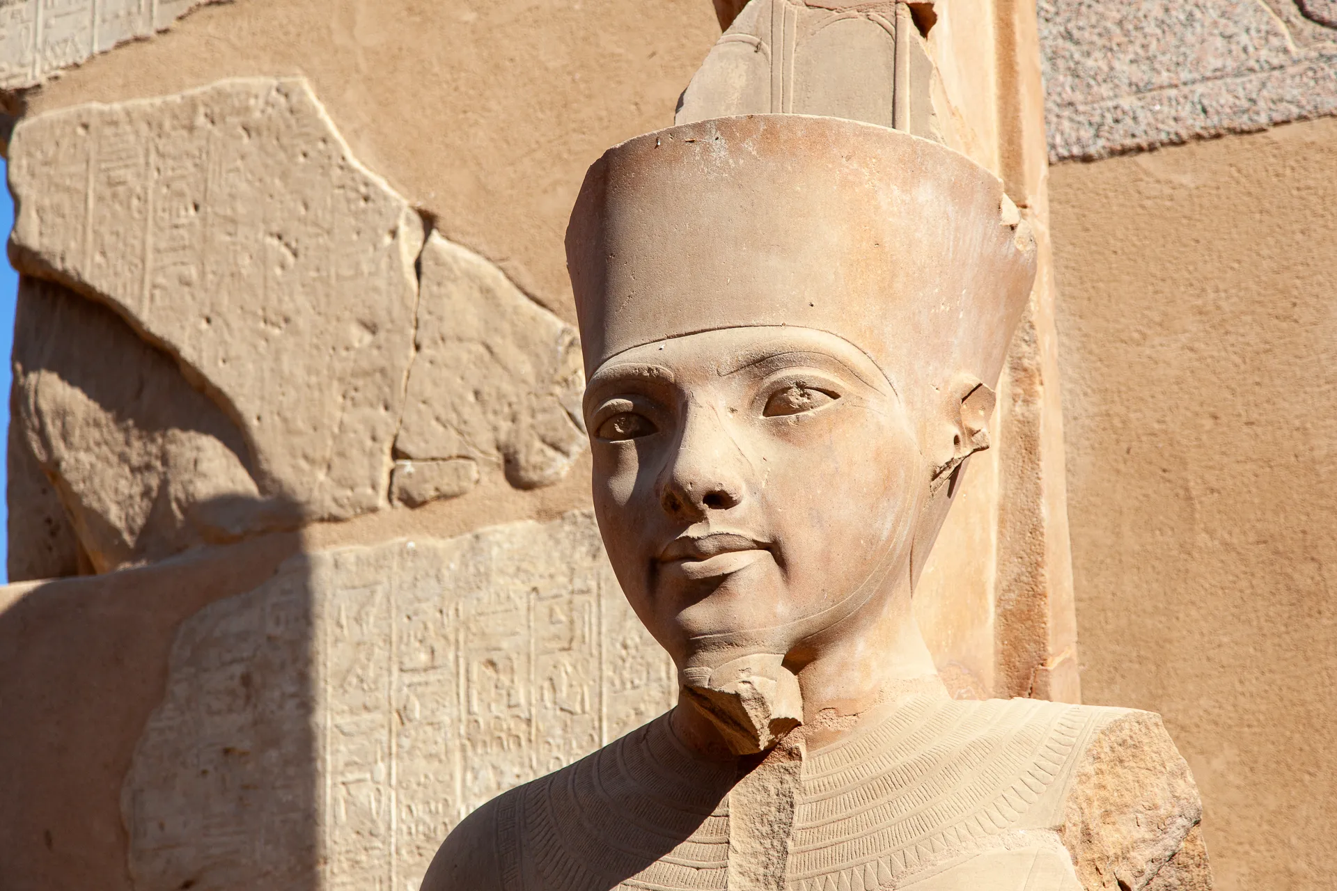 Dettaglio di una statua di faraone scolpita nella pietra.