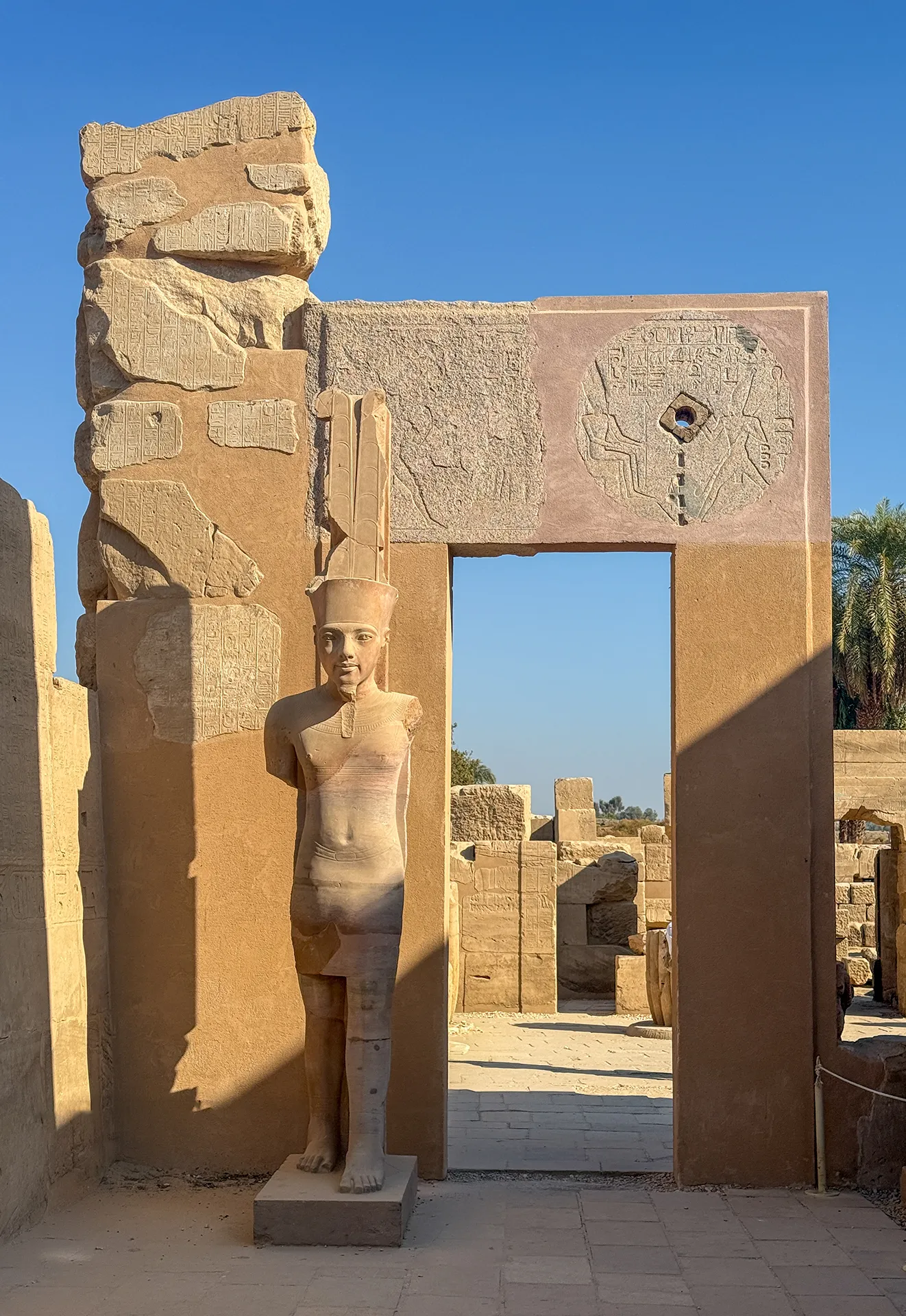 Statua di un faraone e ingresso monumentale nel Tempio di Karnak.