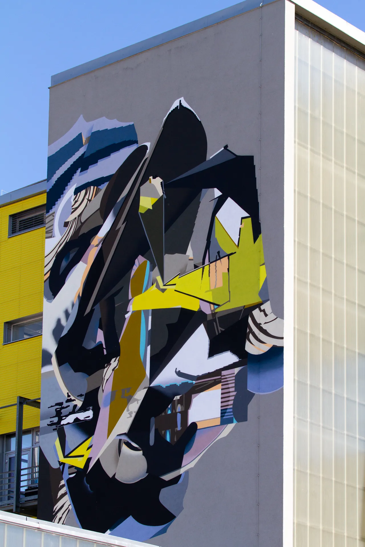Murales astratto con motivi geometrici su una parete di Linz.