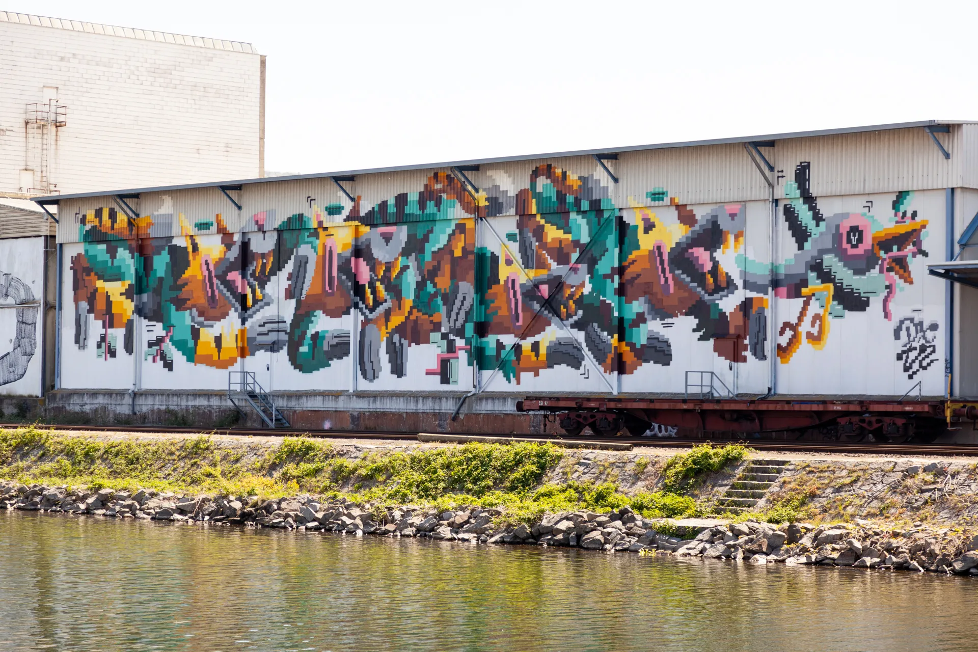 Murales di un uccello fantastico e colorato su un muro industriale a Linz.