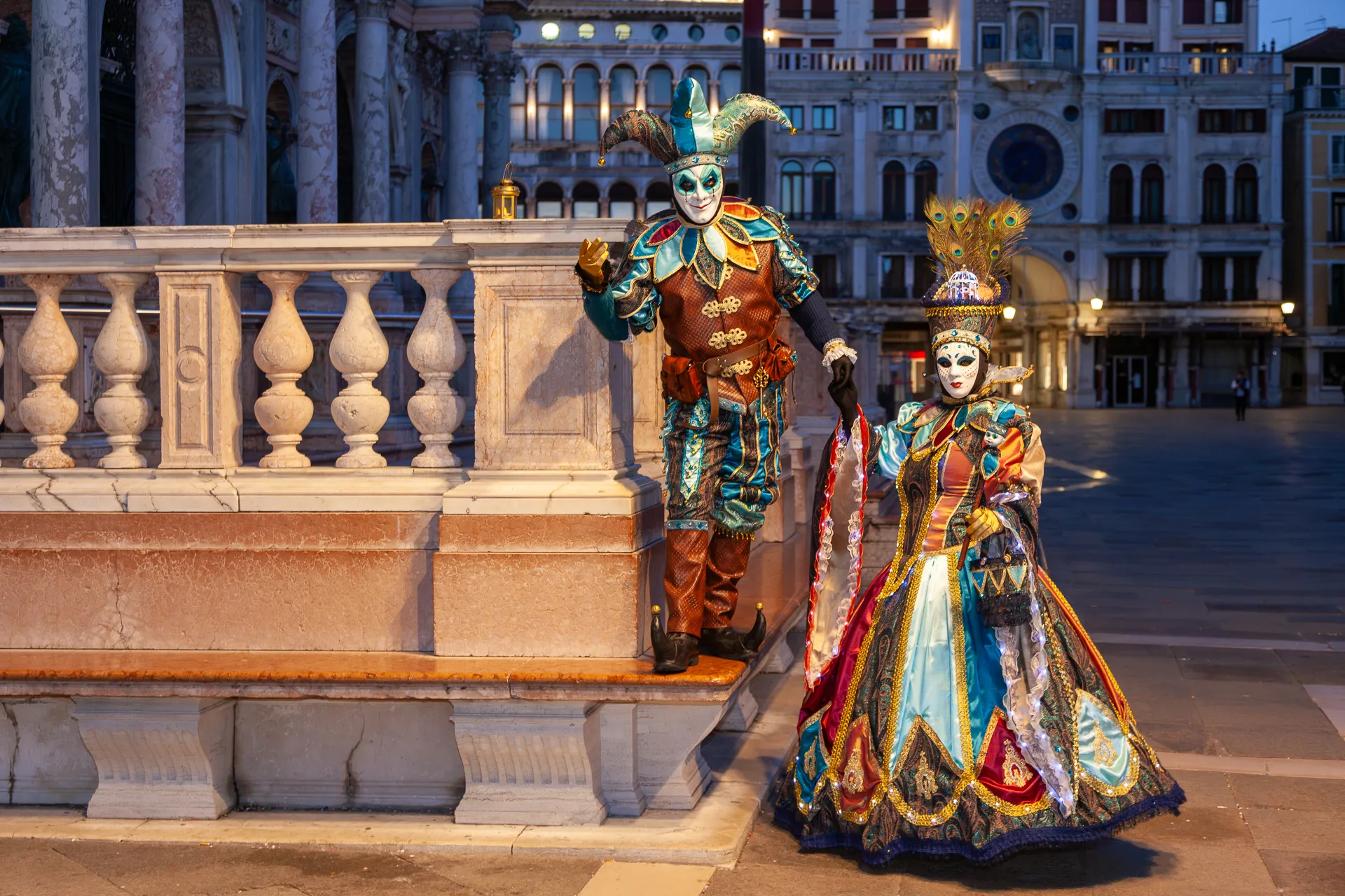 Maschere del Carnevale di Venezia 2025 in abiti barocchi sotto al Campanile di San Marco.