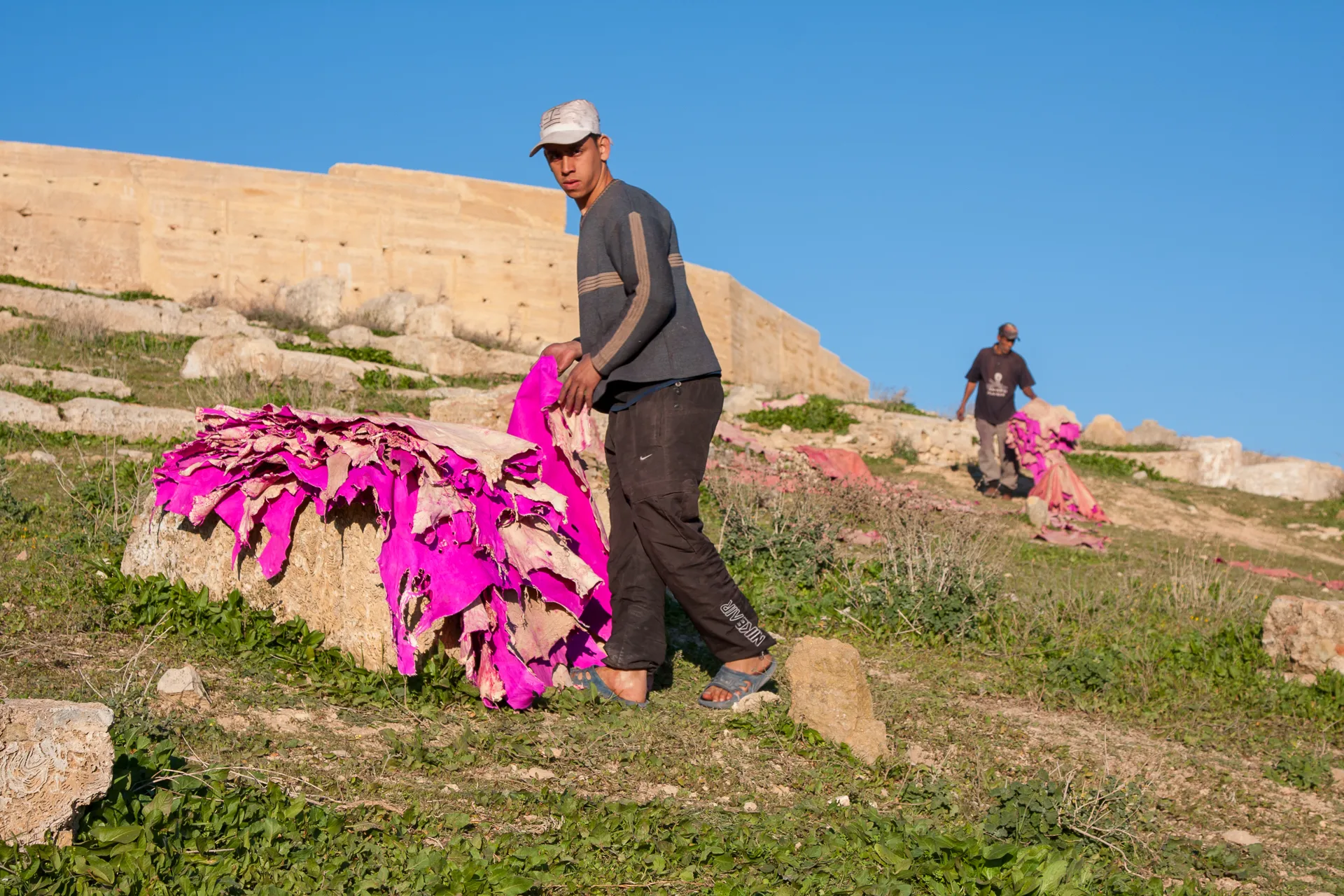 Veduta delle concerie di Fès con lavoratori che trattano le pelli in vasche colorate.