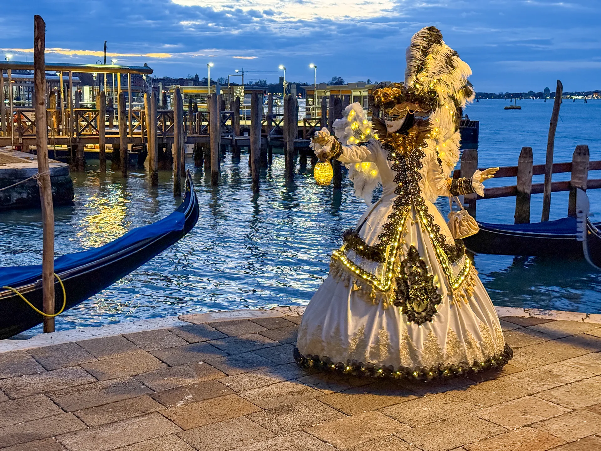 Maschera dorata con lanterna al Carnevale di Venezia 2025