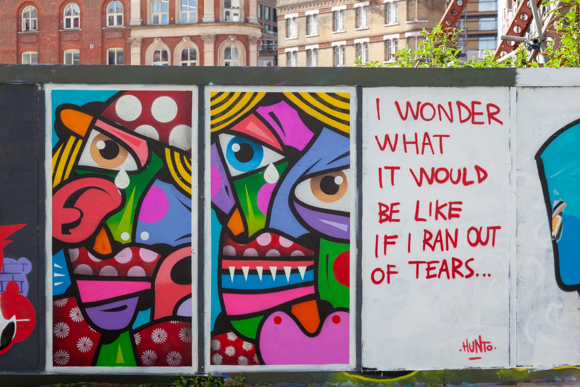 Colori e dolore nei volti cubisti di Hunto, lungo le strade di Brick Lane. Sclater Street, vicino a Brick Lane