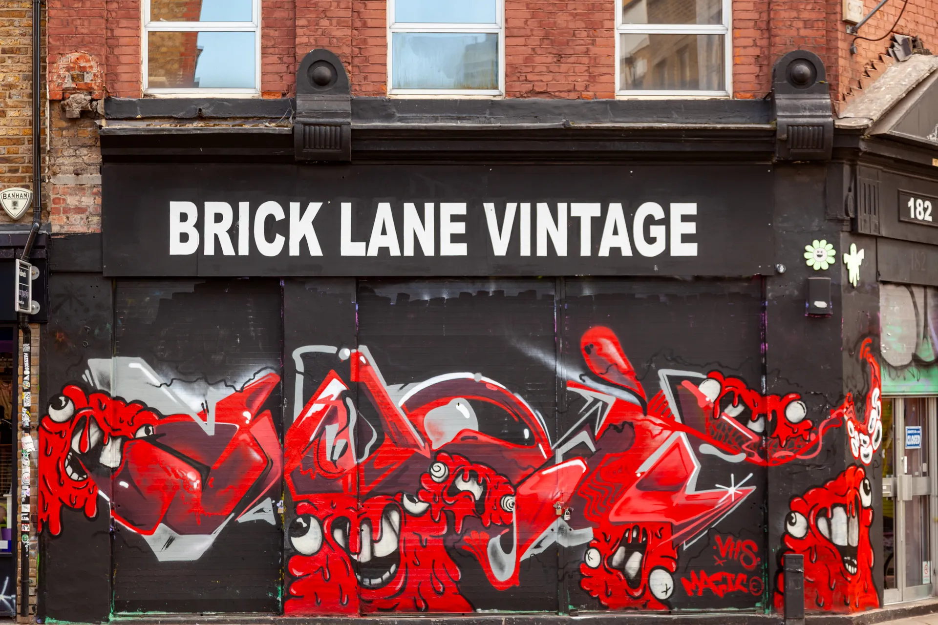 Ironia e colore sulla vetrina chiusa di Brick Lane Vintage. 182 Brick Lane, Londra