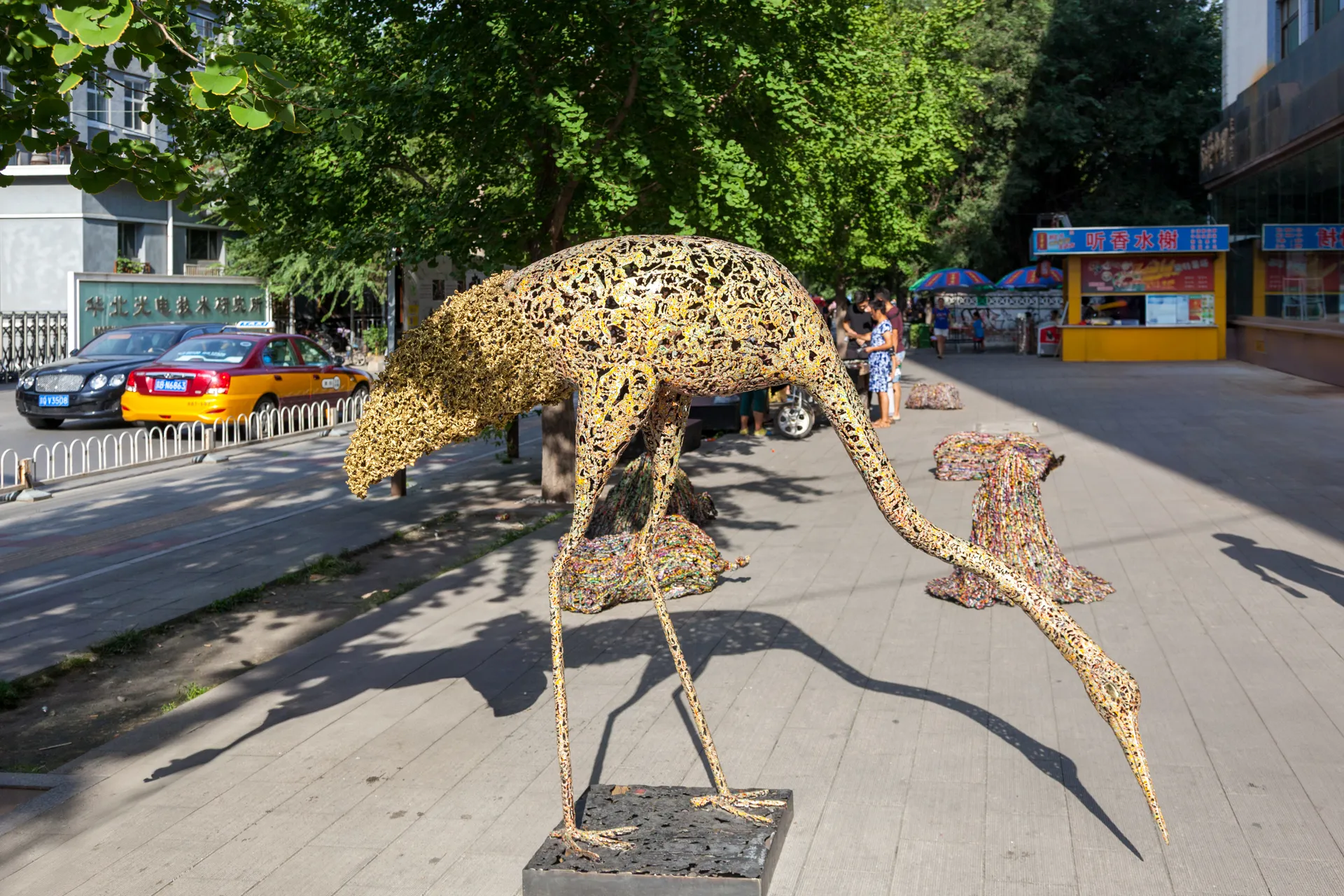 Scultura traforata dorata a forma di uccello in piedi