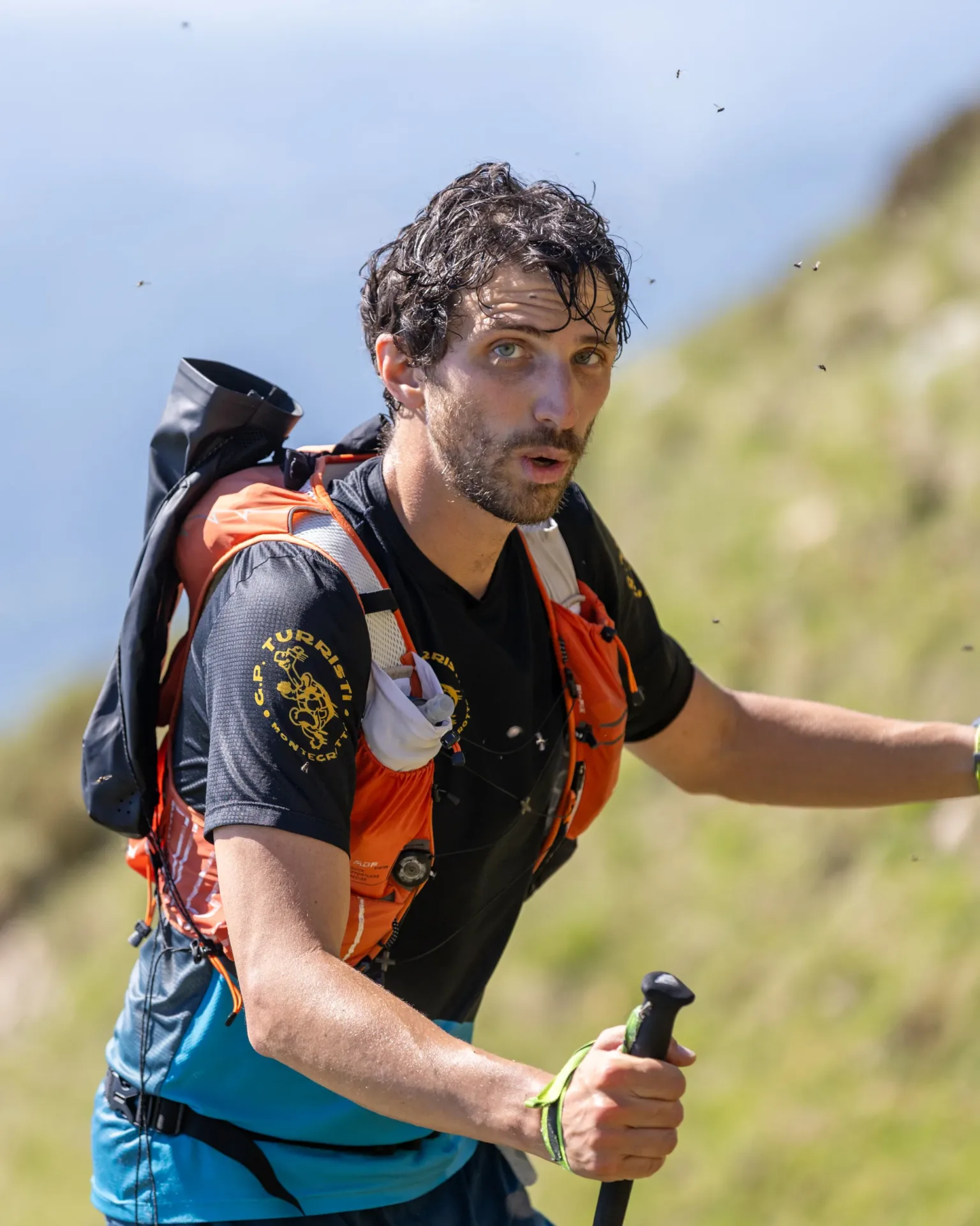 Durona 2026, corridore con bastoncini in primo piano, durante un percorso tra prati, rocce e crinali.